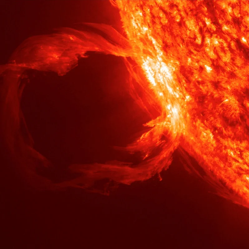 O buclă uriașă de plasmă incandescentă erupând de la marginea Soarelui, fotografiată în ultraviolet extrem